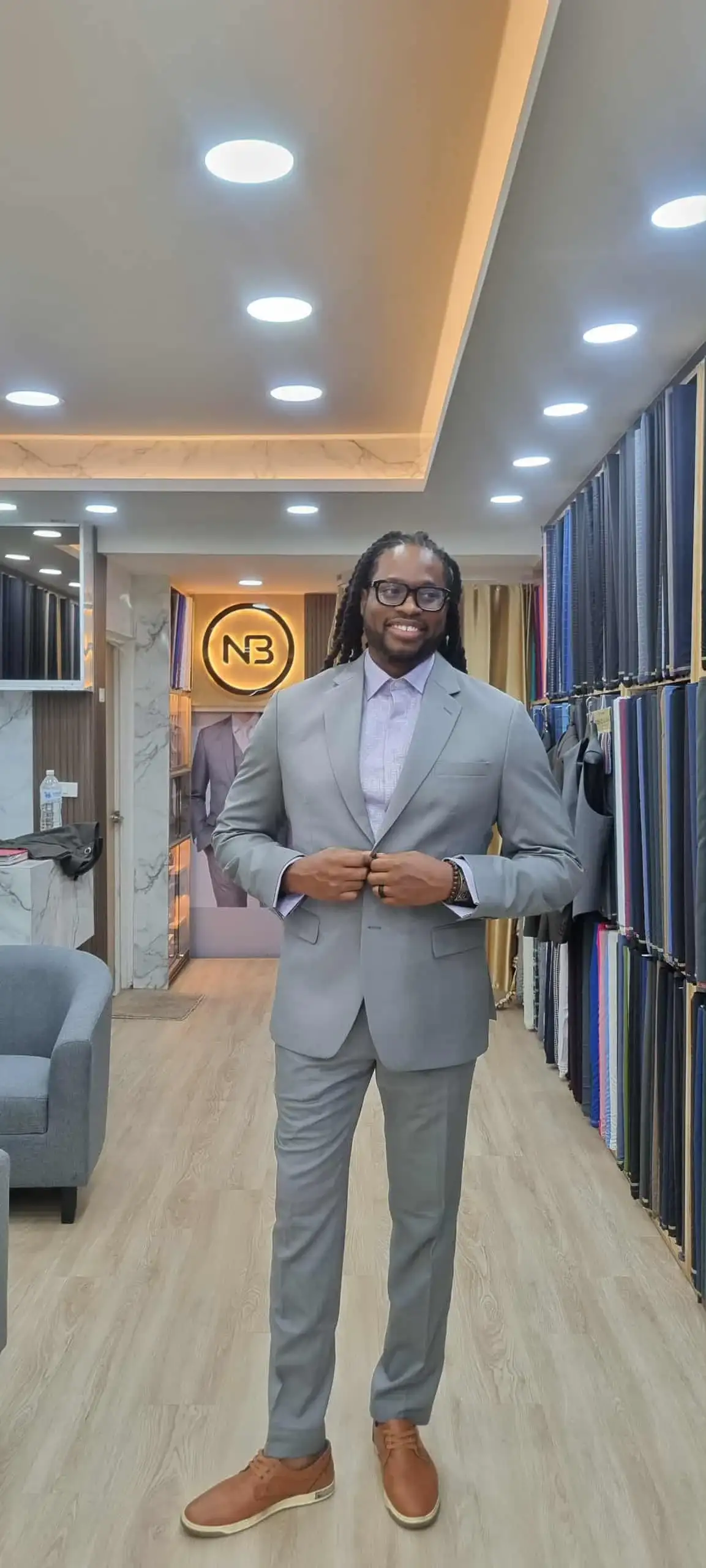 Client wearing light grey tailored suit inside showroom