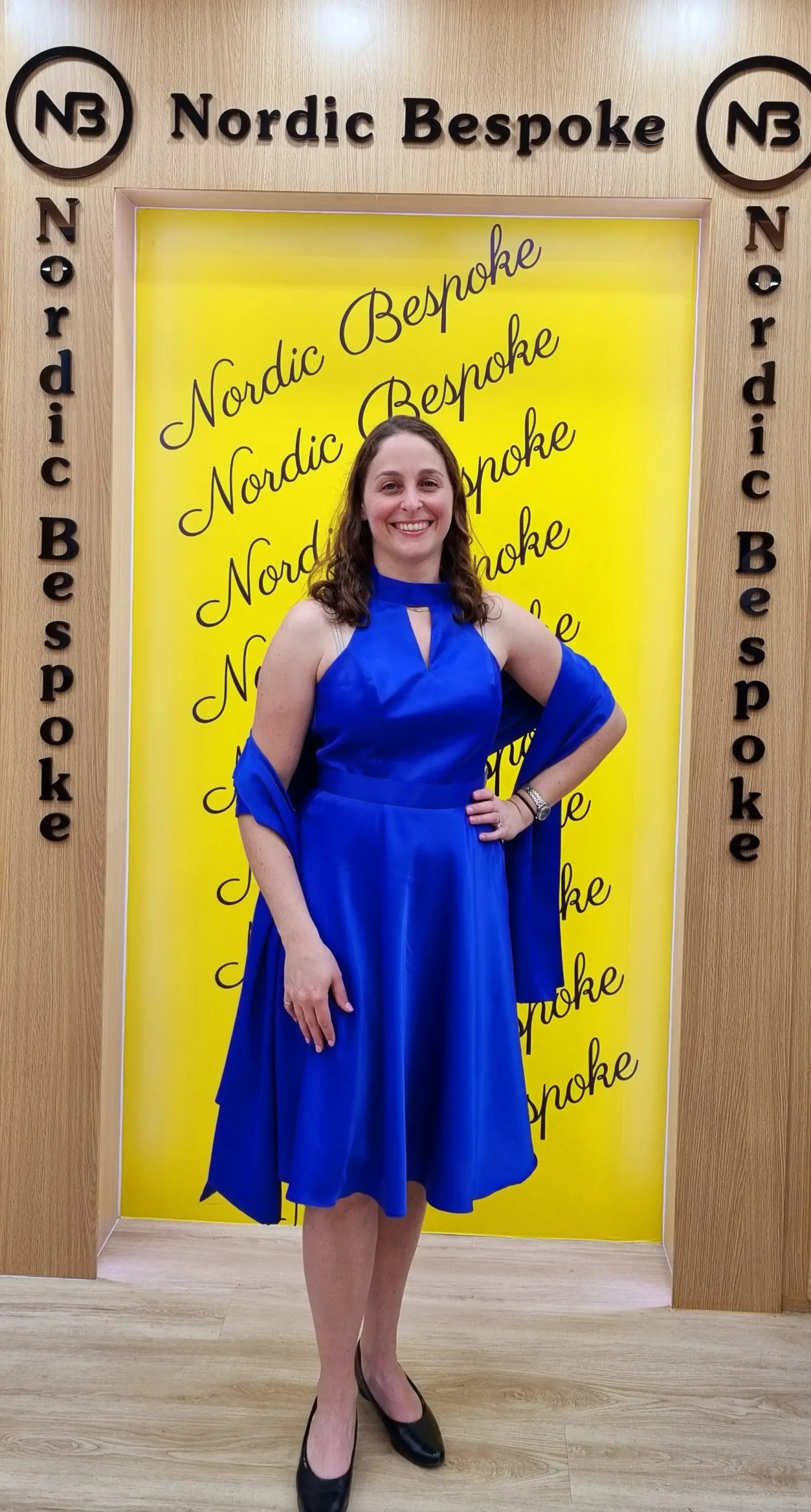 Customer wearing a blue knee-length dress in the showroom