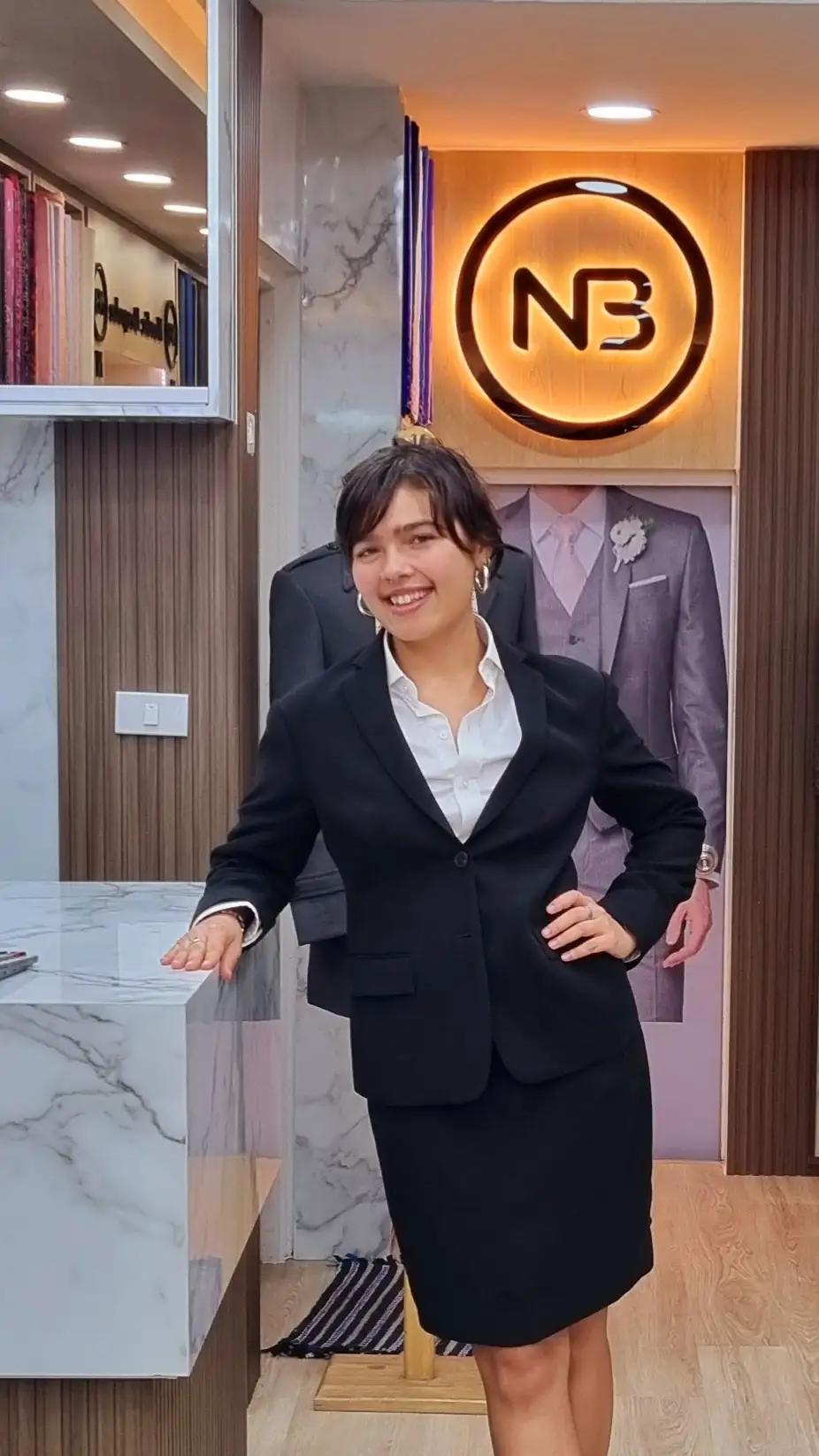 Customer wearing a black jacket and matching skirt in the showroom