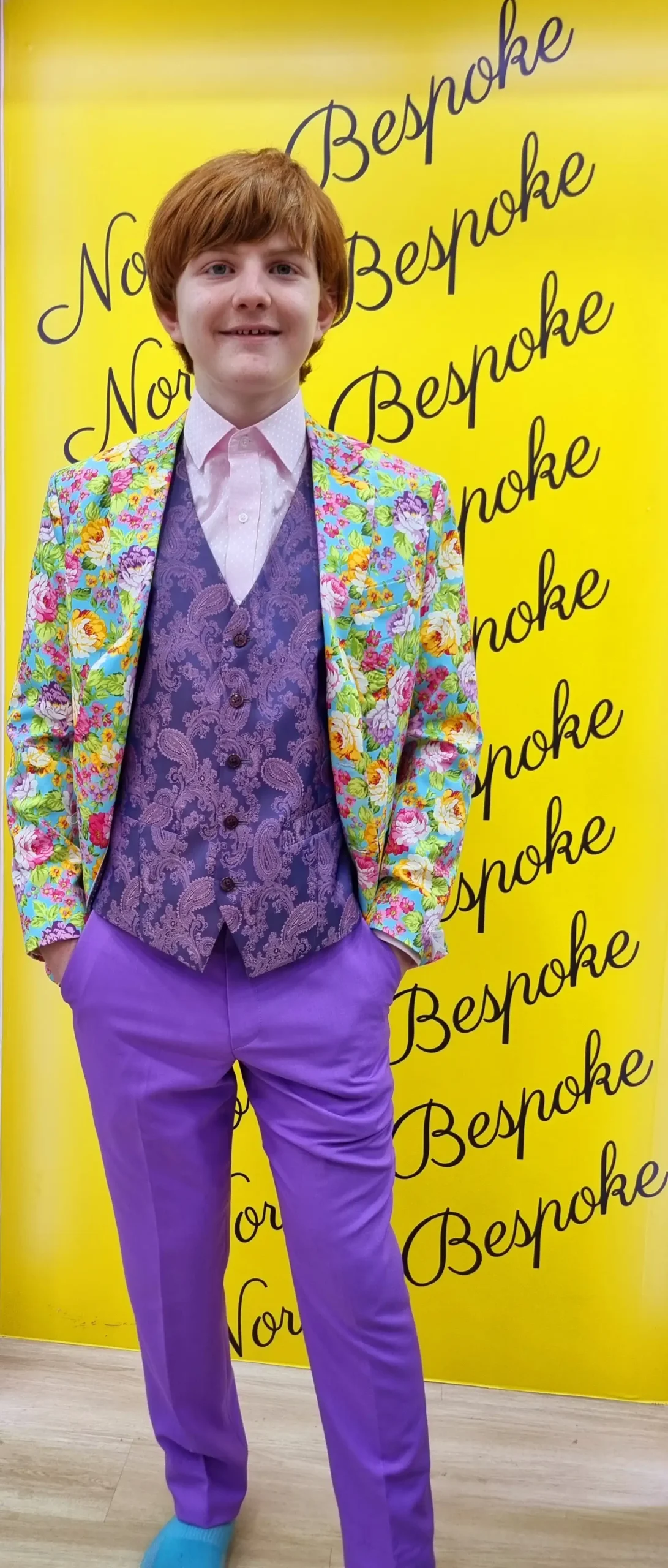 Customer wearing a colourful patterned jacket with purple waistcoat and trousers