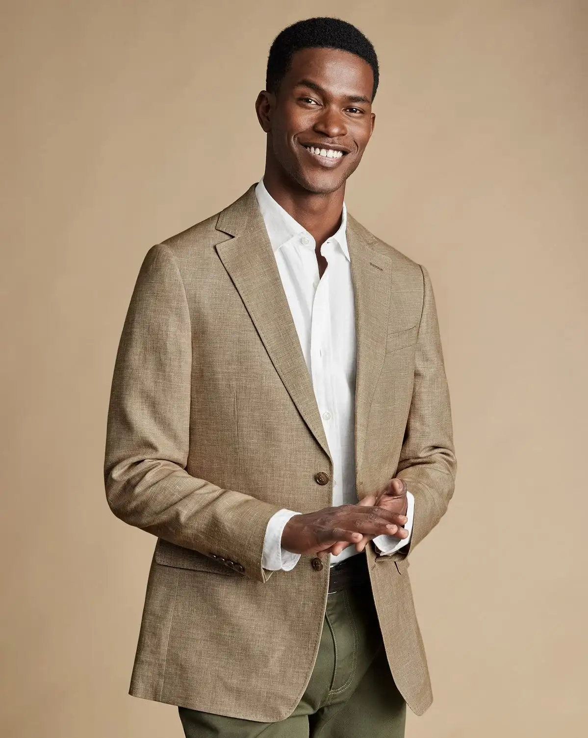 Man wearing a tan blazer with a white shirt
