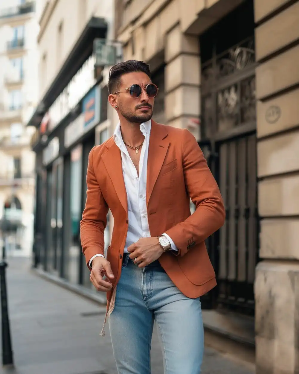Man wearing a rust-coloured blazer with light blue jeans