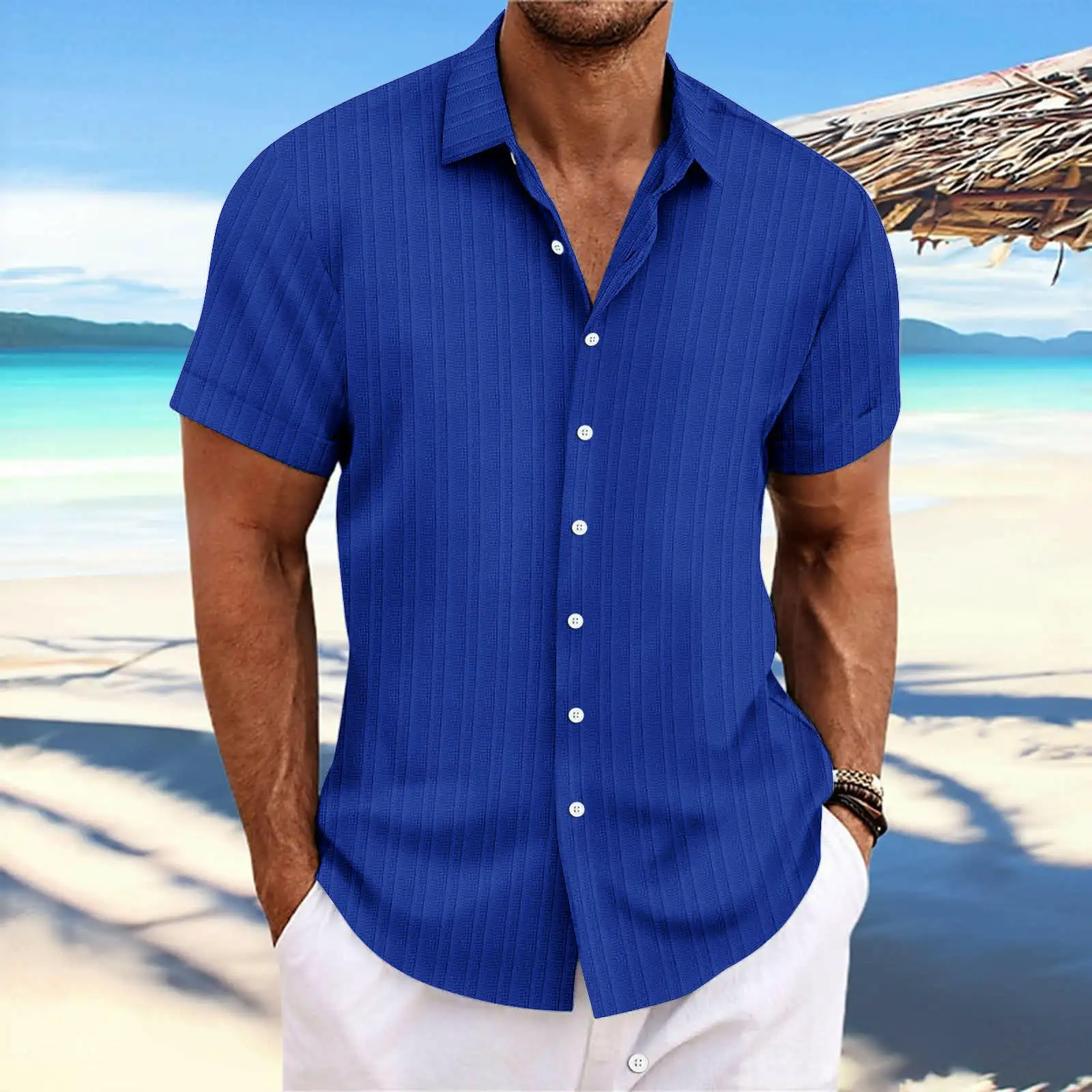 Man wearing a blue short-sleeved shirt with white trousers