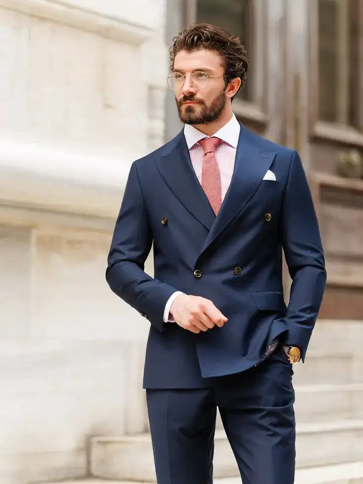 Man wearing a navy double-breasted suit with a pink tie