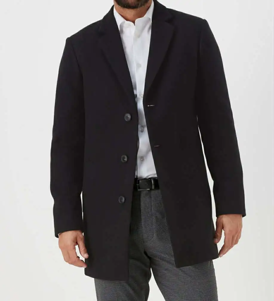 Dark overcoat worn over a white shirt and grey trousers