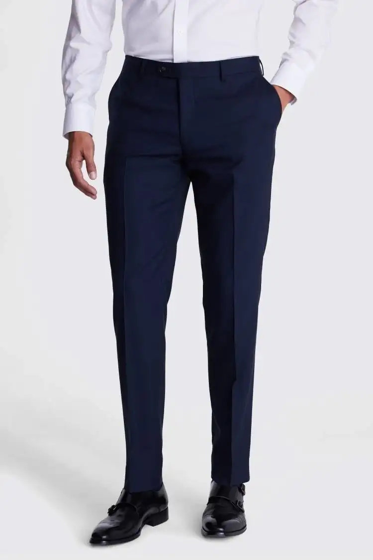 Navy trousers worn with a white shirt and black shoes