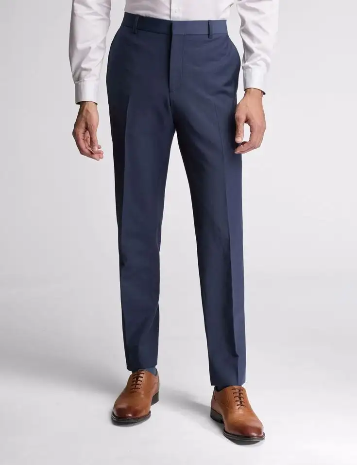 Blue trousers worn with a white shirt and brown shoes