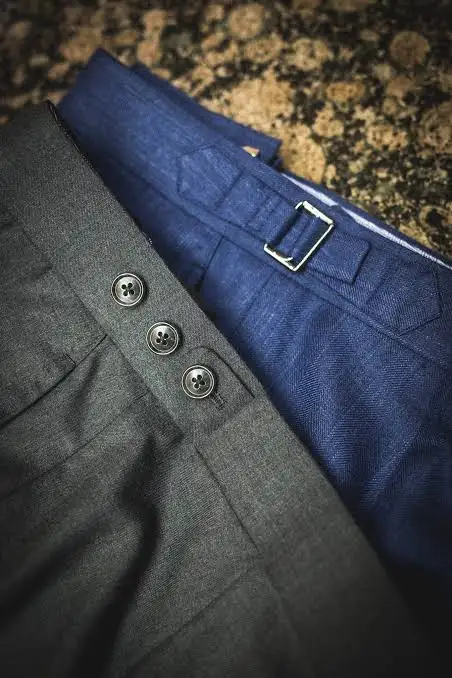 Close-up of blue and grey trouser waistbands with side adjusters