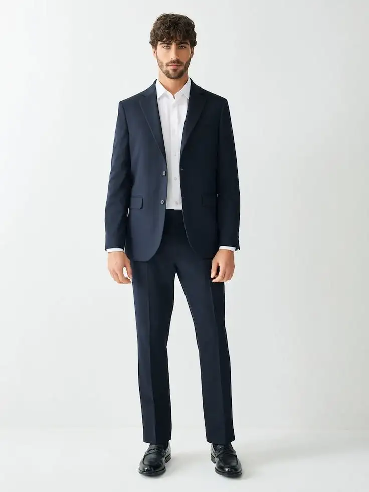Male model wearing dark navy two-piece suit with single-breasted blazer over white shirt and matching trousers – Nordic Bespoke Tailor formal menswear style