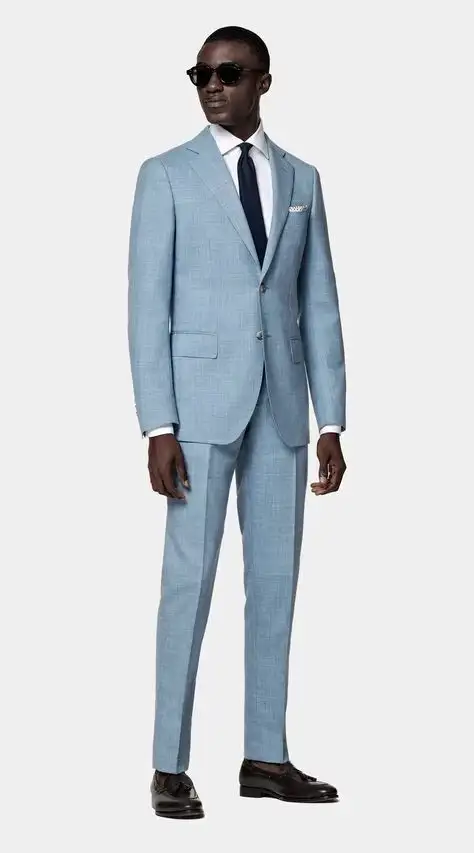 Male model wearing light blue two-piece suit with tailored jacket and trousers, paired with white dress shirt, navy tie, pocket square and sunglasses – Nordic Bespoke Tailor stylish menswear
