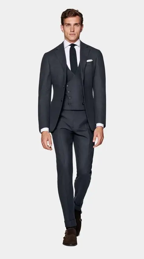 Male model wearing charcoal grey three-piece suit with tailored blazer, waistcoat and trousers, paired with white dress shirt and black tie – Nordic Bespoke Tailor formalwear