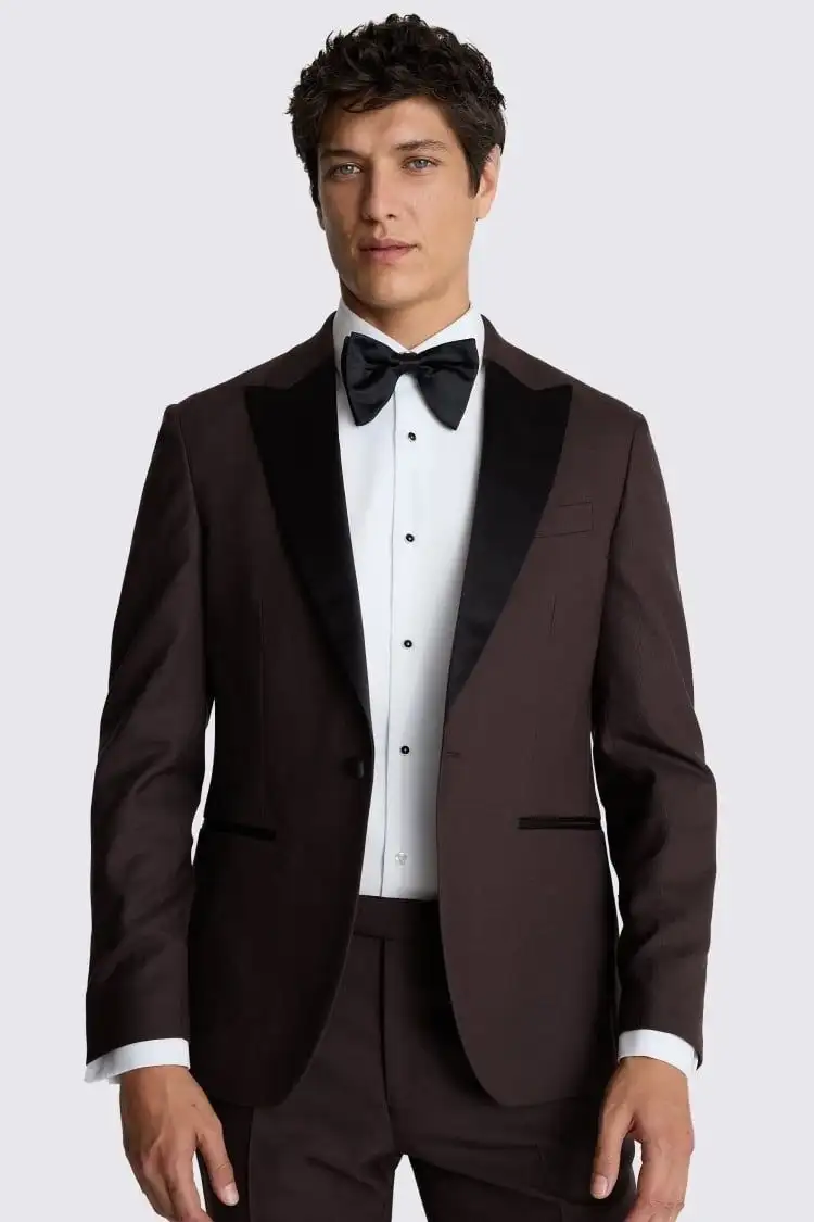 Man wearing a dark brown tuxedo with contrasting lapels and a bow tie