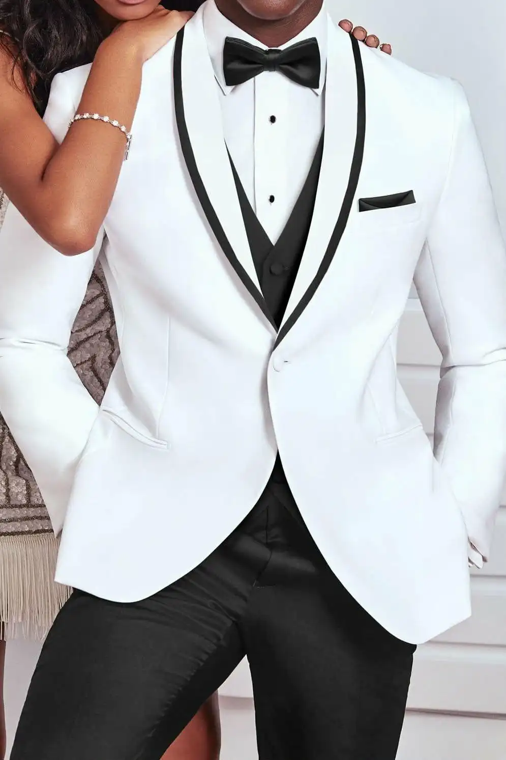 White tuxedo jacket with black trim, matching waistcoat and bow tie