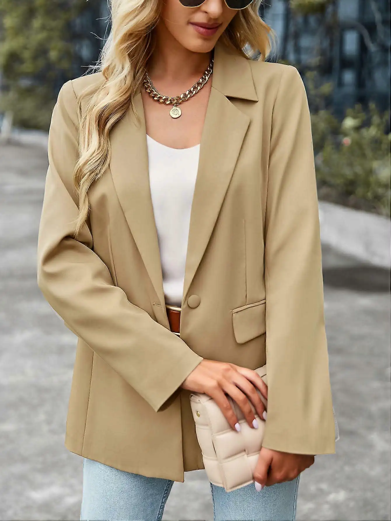 Woman wearing a beige blazer over a white top