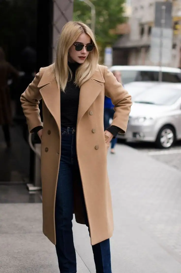 Woman wearing a camel-coloured overcoat over a black outfit