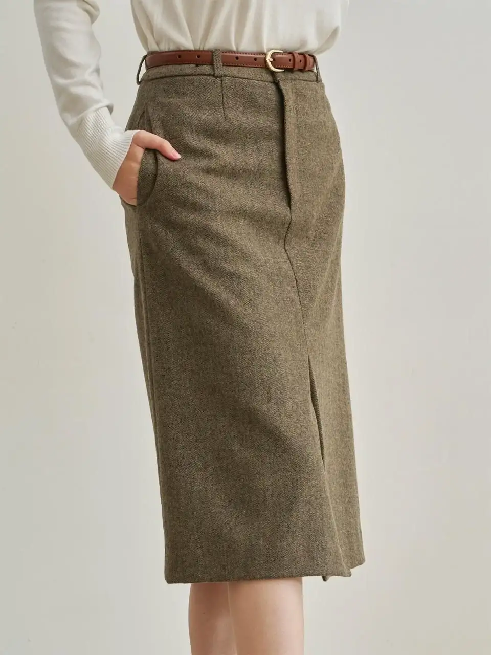 Women’s high-waisted tweed pencil skirt with front slit and brown belt, paired with tucked-in white blouse – bespoke women's skirt design
