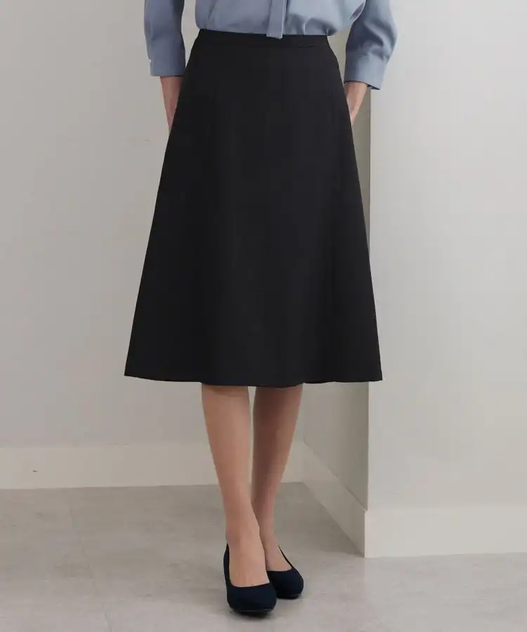 Black A-line skirt worn with a blue shirt and black shoes