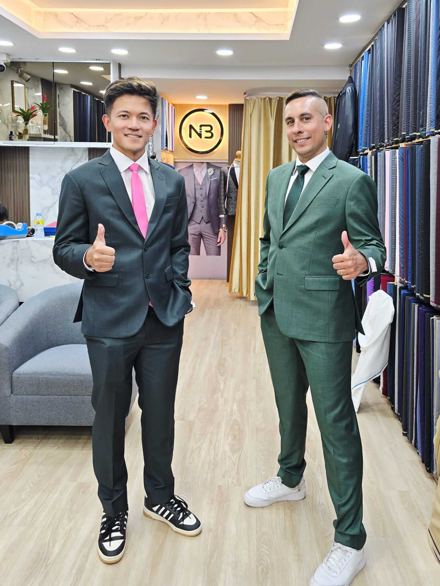 Two customers wearing dark and green suits in the showroom