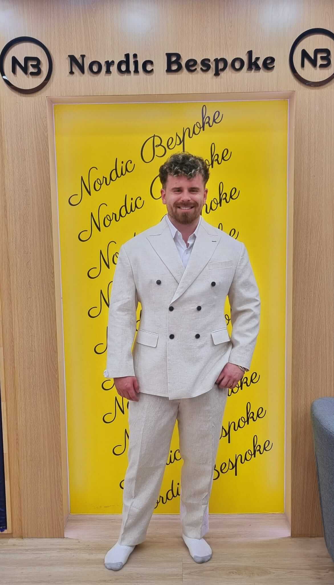 Customer wearing a white double-breasted suit with white trainers