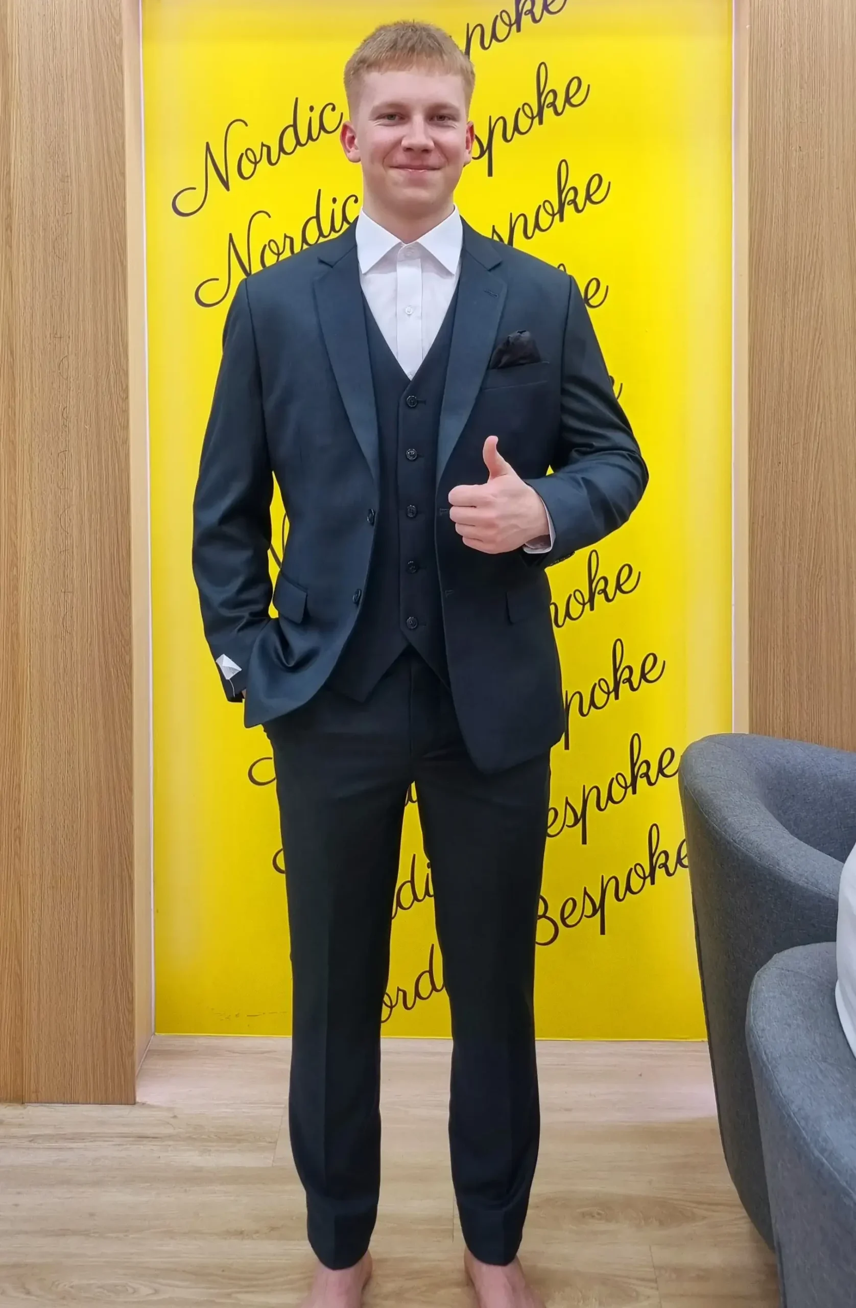 Customer wearing a dark three-piece suit in the showroom