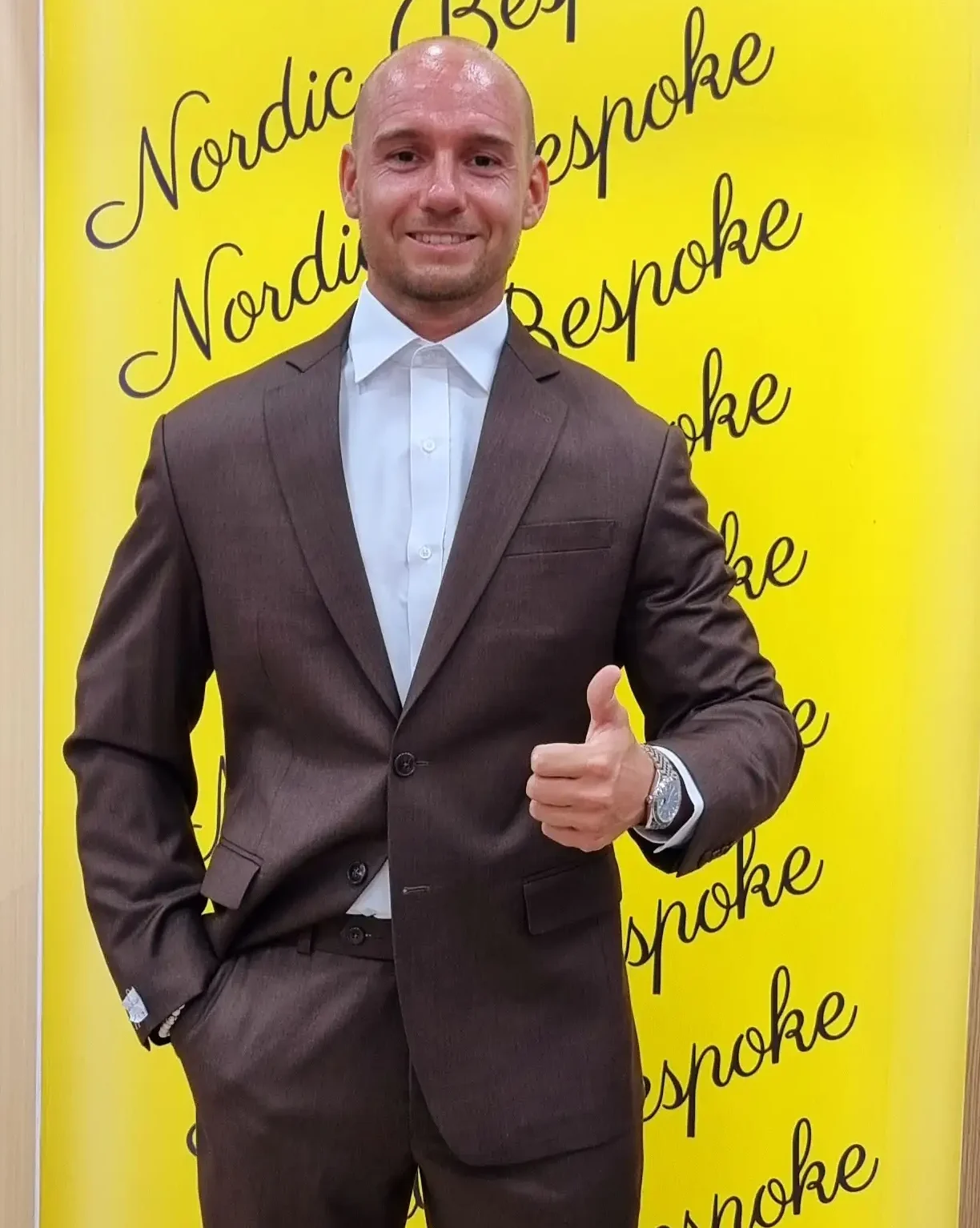 Customer wearing a brown three-piece suit with white trainers